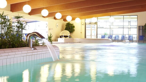 nnenbereich der Franken‑Therme mit Becken, Wasserlauf und Liegen.